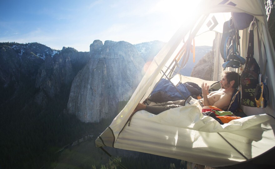 Climber Kevin Jorgeson examines his worn fingers as he rests in his portaledge on El Capitan's Dawn Wall.