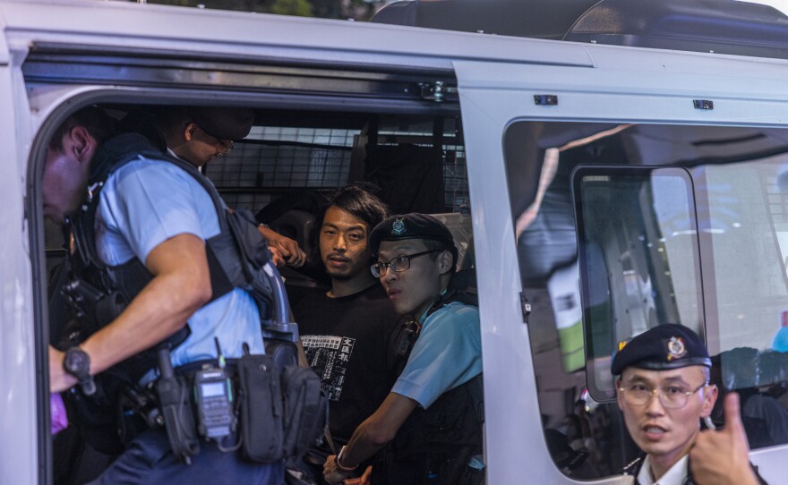 Activist Leo Tang is taken away on Sunday by police near Hong Kong's Victoria Park, the city's venue for the annual 1989 Tiananmen massacre vigil.