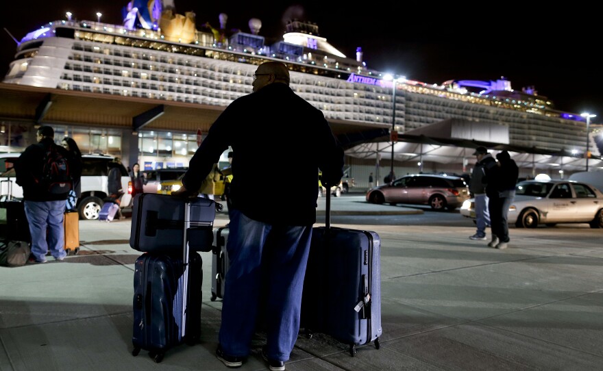 A passenger from the Royal Caribbean cruise ship Anthem of the Seas waits for transportation after arriving at the Cape Liberty cruise port in Bayonne, N.J., Wednesday. The ship was forced to turn around after hitting a strong storm at sea.