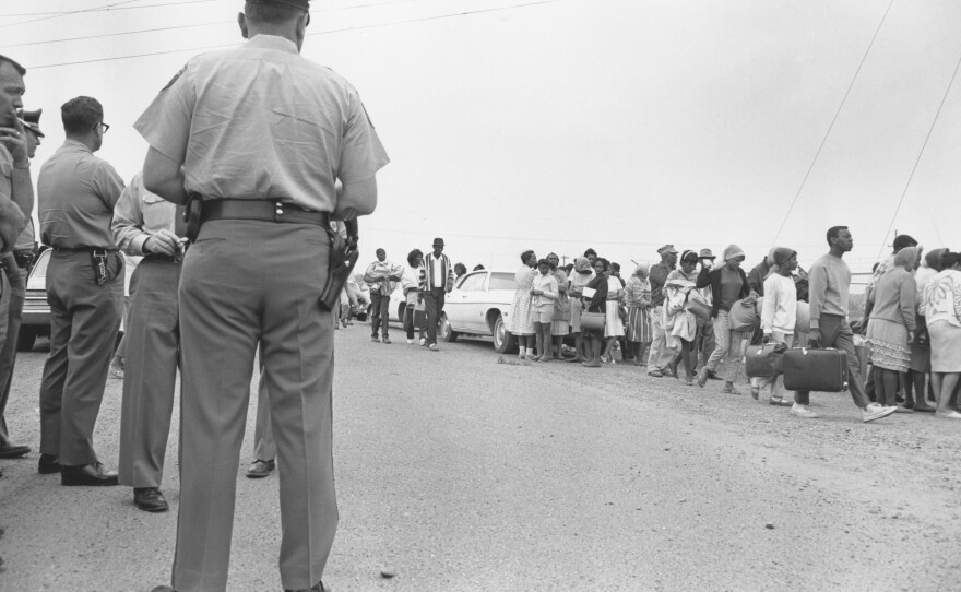 Local police officers and state troopers on patrol as participants prepare to leave on the caravan in Marks, Miss.