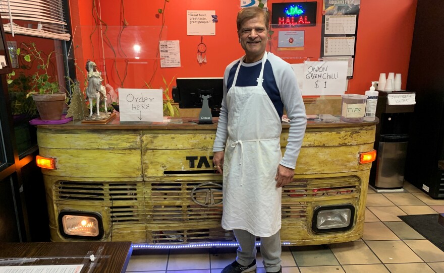 Jagdeep Nayyar, owner and chef at My Taste of India, stands in front of the register stand that's made from the front panel of a real Tata truck — the best-selling brand in India.