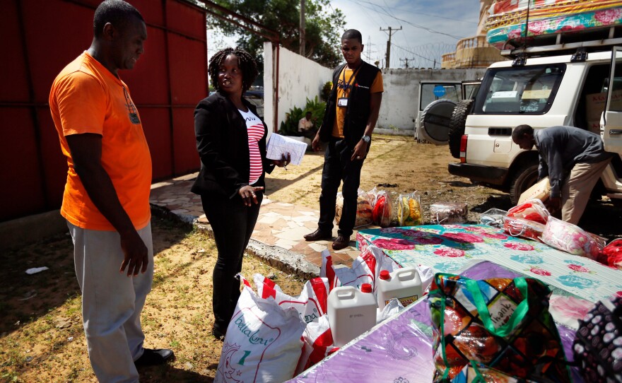 Sienna Wisseh, of Liberia's Social Welfare Department, center, directs the packing of supplies that will be given to the families adopting or reuniting with children.