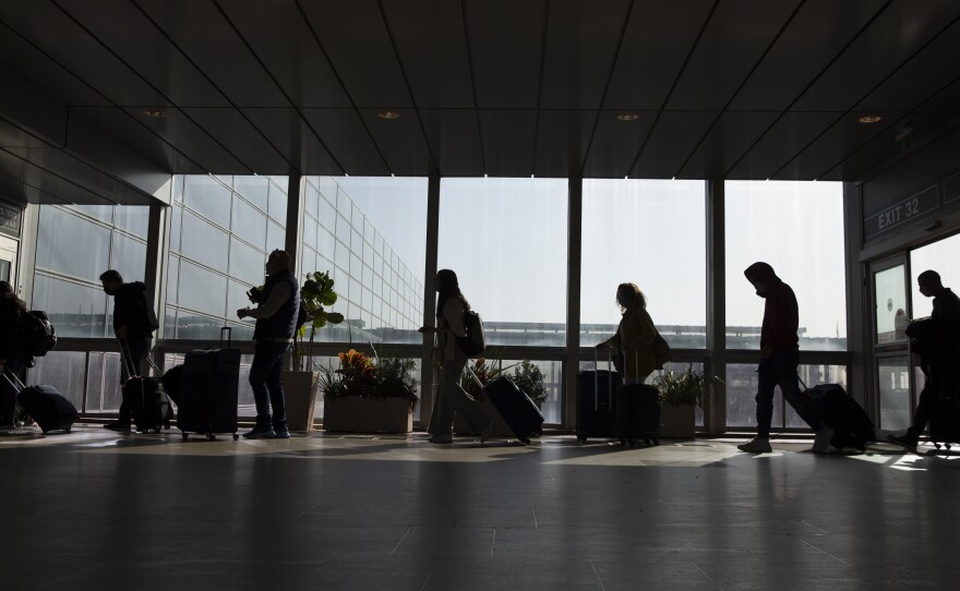 Travelers walk with their luggage in the Ben Gurion Airport near Tel Aviv, Israel on Sunday.