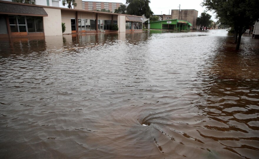 Water drains on a street flooded by rain from Hurricane Harvey in 2017 in Galveston, Texas. After getting new rainfall data, some Texas cities are building infrastructure to handle more water.