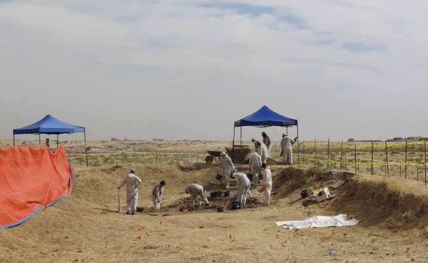 Iraqi workers and international investigators excavate a mass grave known as "the mother's grave" in the Sinjar region of northern Iraq in October. The grave in the village of Solagh is believed to hold more than 80 bodies of women ISIS considered too old to sexually enslave and heavily pregnant women it did not want to transport.