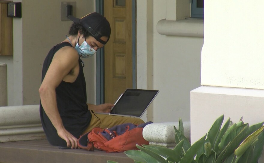 A student works on laptop outside on the campus of San Diego State, August 31, 2020.