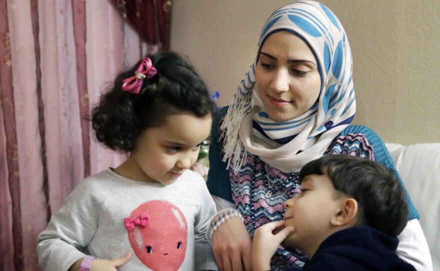 Syrian refugee Maryam al-Jaddou sits with her children Maria (left) and Hasan in their apartment in Dallas. Jaddou says she decided to leave Syria in 2012 after her family's home in Homs was bombed and there was nowhere safe left to live.