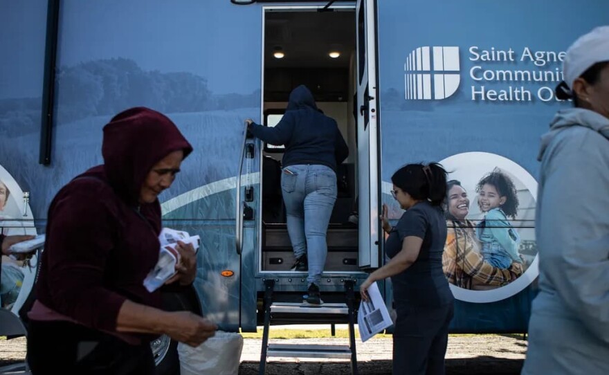 A patient walks into the Saint Agnes Mobile Health Unit mobile clinic, parked in the parking lot of Rojas Pierce Park in Mendota on May 21, 2025.