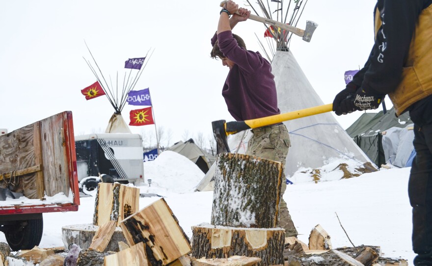 Jacob Chamberlain, 22, of Scotland chops firewood to use in fireplaces installed inside camp shelters. He plans to stay in North Dakota until the pipeline project is defeated.