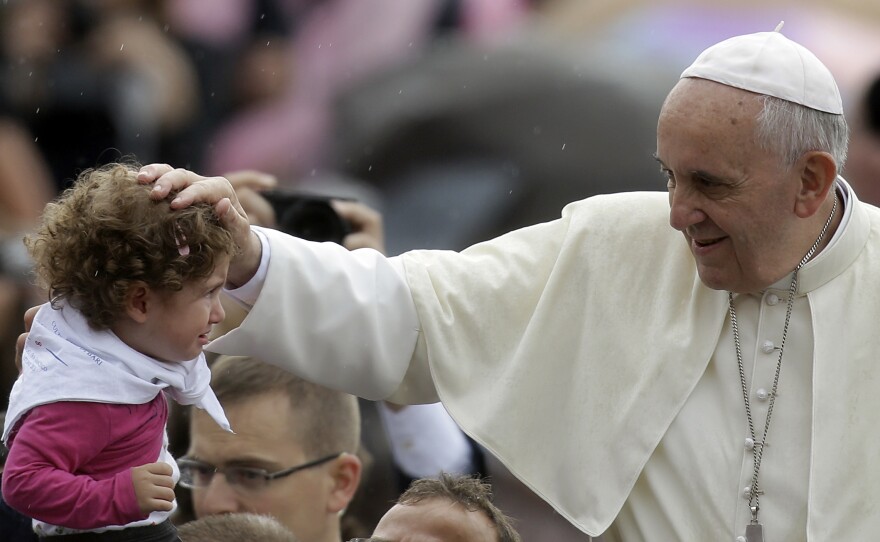 Pope Francis blesses a child during the weekly general audience in St. Peter's Square at the Vatican in October.