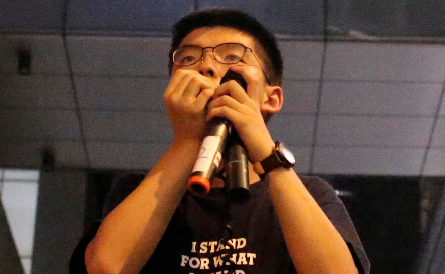 Joshua Wong speaks to protesters outside police headquarters in Hong Kong on June 21.