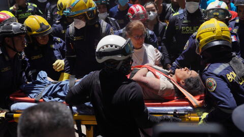 Rescue workers carry Diana Troncoso after pulling her from the rubble the day after an earthquake struck Cali, Colombia, Tuesday, Aug. 11, 2026.
