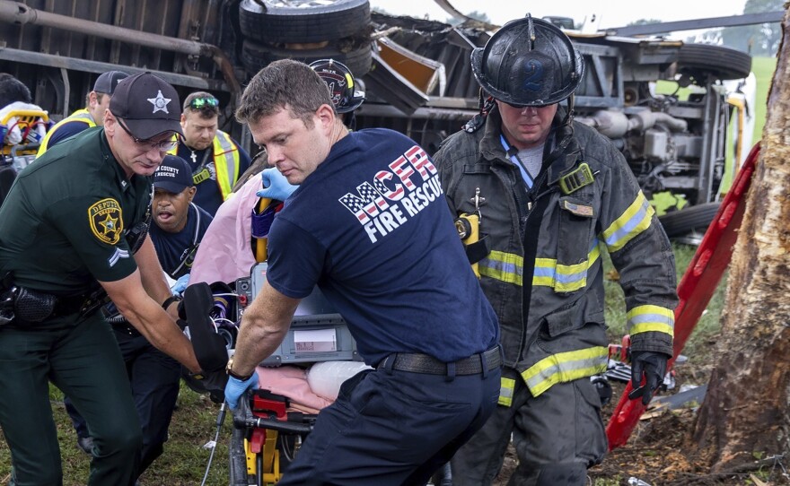 Crews from Marion County Fire Rescue and the Marion County Sheriff's Office assist victims after a bus carrying farmworkers crashed and overturned early Tuesday Ocala, Fla.