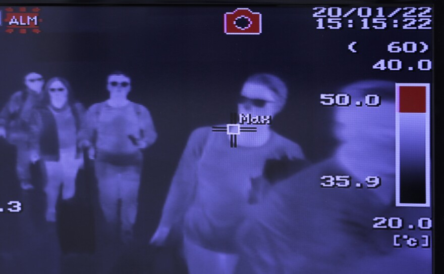 Airports began taking measures to identify infected passengers early on. A monitor displays images of a thermal scan of passengers at Narita Airport in Japan on Jan. 22, 2020.