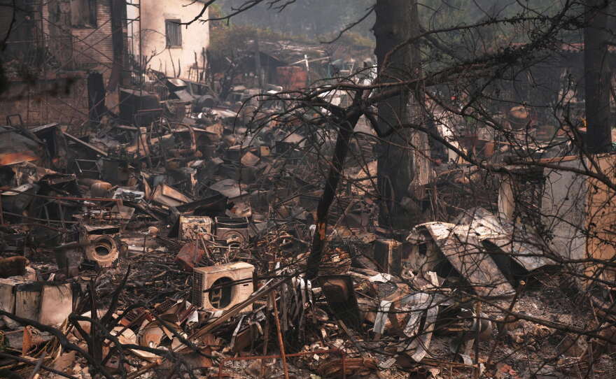 A house and belongings destroyed by a wildfire are photographed as the fire continues to spread near Pelayos de la Presa, Madrid province, Spain, Tuesday, July 28, 2026.