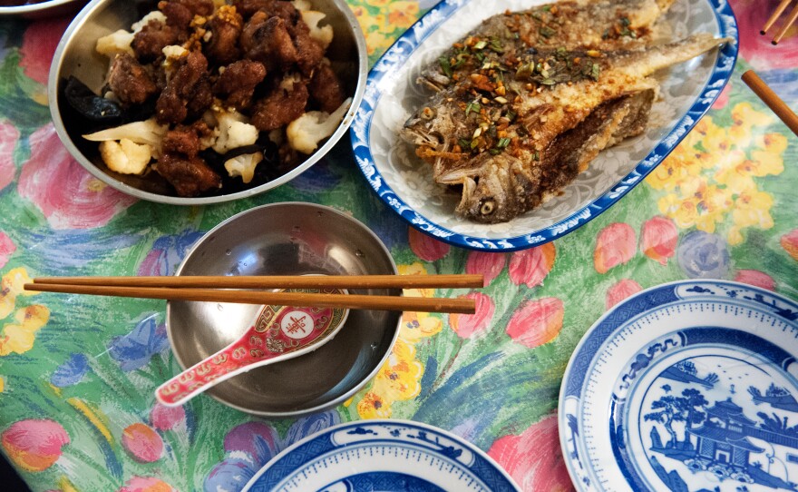 Plates of drunken pork ribs and deep-fried yellow croaker with savory soy sauce fill the dining table of Ni's home in New York City.