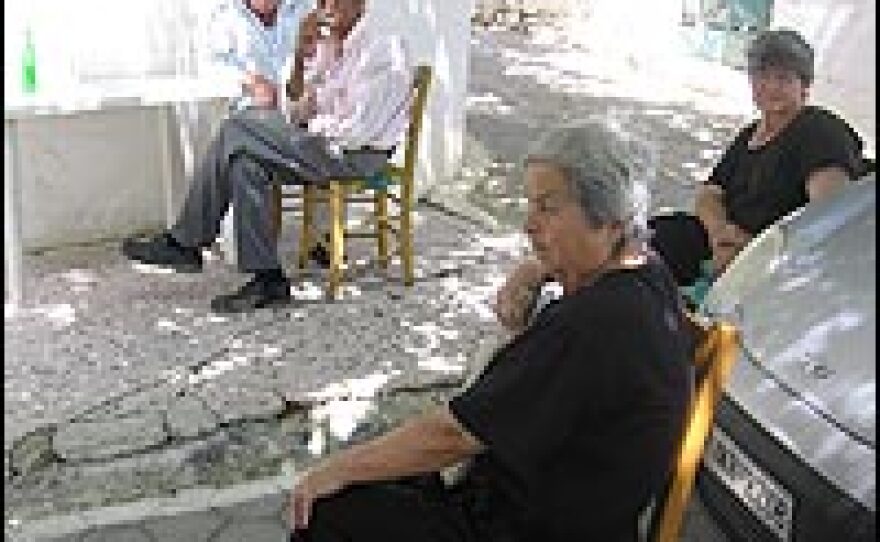 Residents of a small village in Crete sit in the shade and drink water from a mountain spring to keep cool on a day when the temperature hit over 100 degrees.