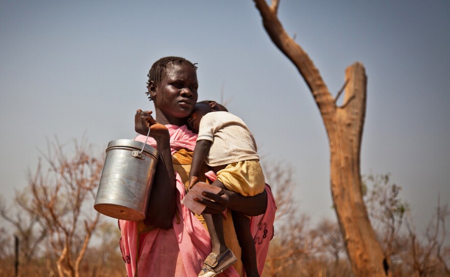 A displaced woman and her child from the Nuba Mountains in Sudan wait outside the Yida refugee camp registration center in Yida, South Sudan April 26. Thousands of people from the Nuba Mountains in South Kordofan, Sudan have fled to Yida to escape recent fighting and airstrikes by Sudan's Armed Forces.
