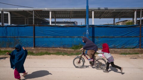 Children ride a bicycle and play in the Roj camp in a Kurdish-held territory in northeast Syria in March. The detention camp houses wives and children of ISIS members.