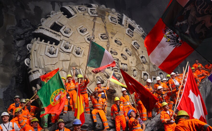 Miners celebrate beneath the Swiss Alps in 2010, after a giant drilling machine bored through to create the world's longest tunnel. After several more years of work, the train line through that tunnel is now open.