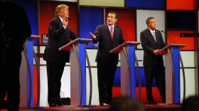 Republican presidential candidates, businessman Donald Trump and Sen. Ted Cruz, R-Texas, argue as Ohio Gov. John Kasich listens during a Republican presidential primary debate at Fox Theatre in Detroit, March 3, 2016.