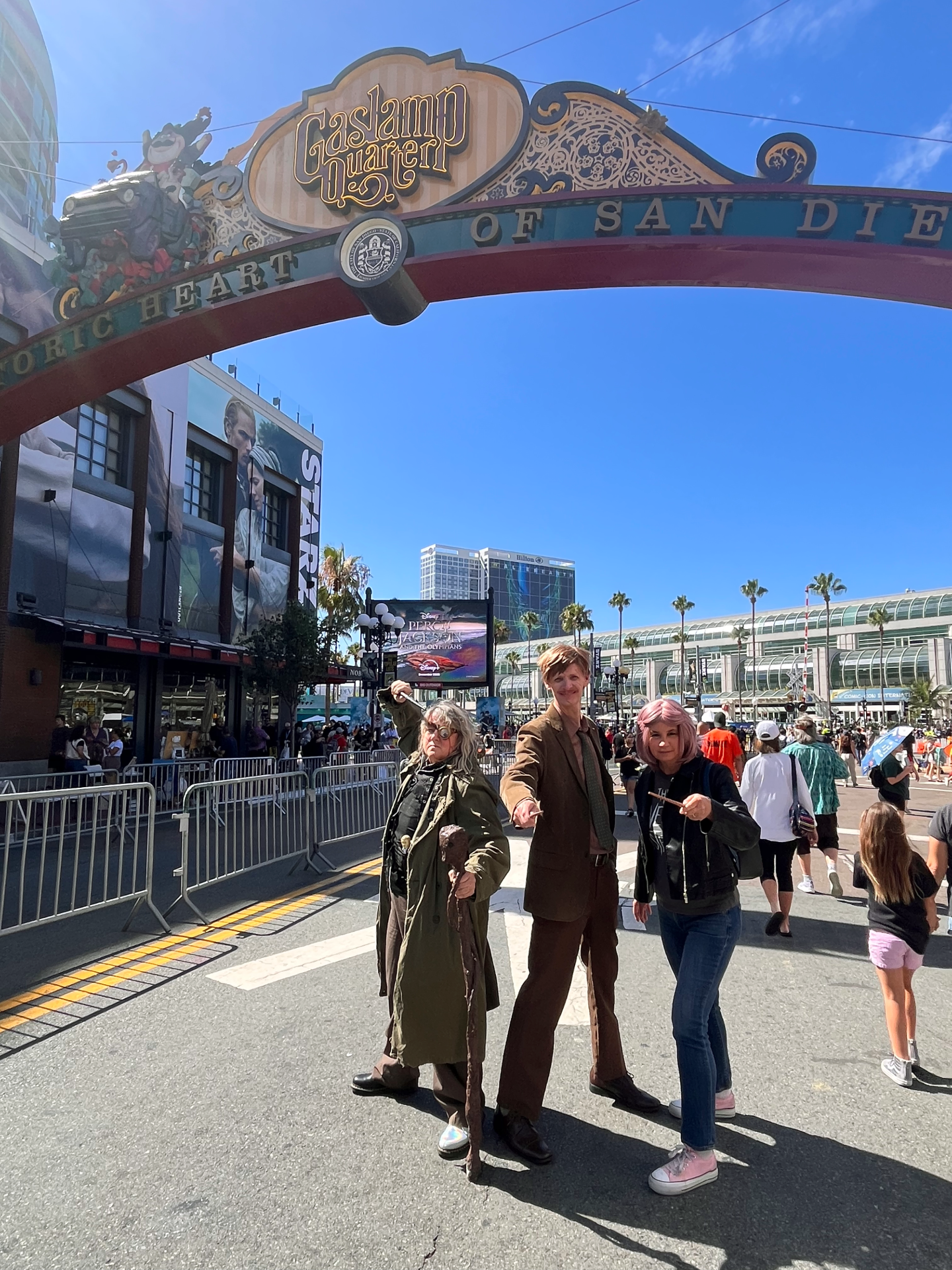 Kat Baxter, Jason Baxter and Andrea Steele cosplay as Tonks, Lupin and Mad-Eye Moody from "Harry Potter" beneath the Gaslamp Quarter sign at Comic-Con on July 25, 2025.