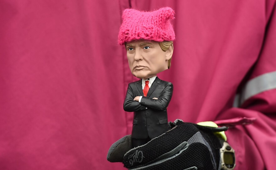 A protester holds a Donald Trump bobble-head donned with a tiny pink "pussy hat" during Saturday's march in D.C.