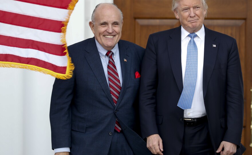 Rudy Giuliani is seen here with Donald Trump shortly after Trump's election victory in 2016. Federal authorities raided Giuliani's apartment Wednesday, the former New York City mayor's attorney said.