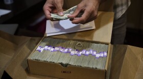 An owner of a medical marijuana dispensary in Los Angeles prepares his monthly tax payment, June 27, 2017. 