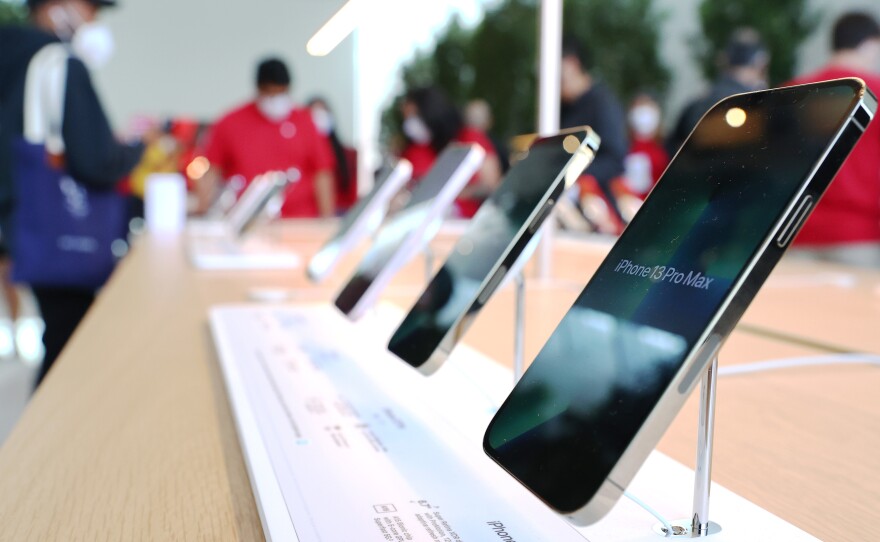 iPhones are displayed as people attend the grand opening event of a new Apple store in Los Angeles on Nov. 19, 2021.