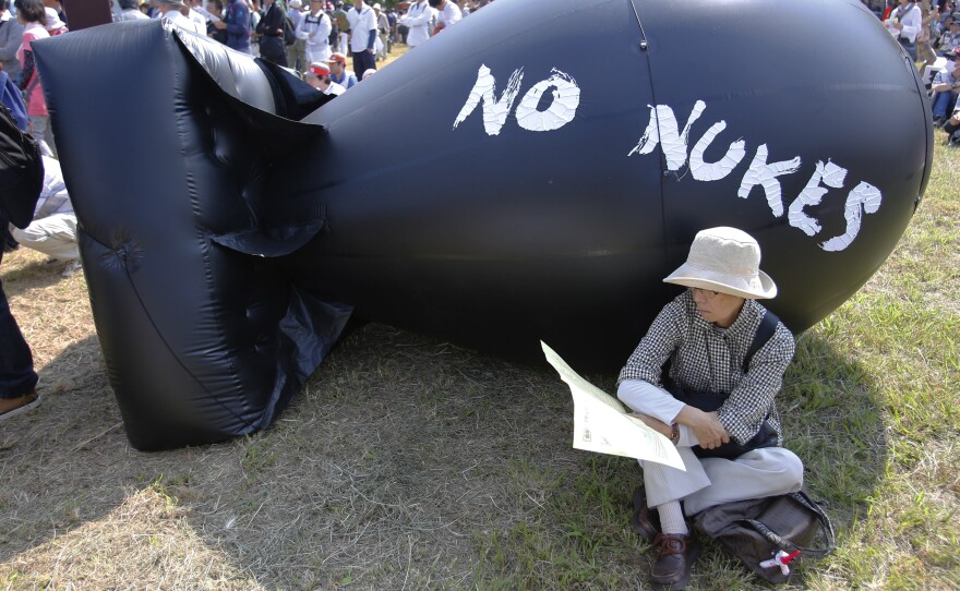 An anti-nuclear protester rests in front of bomb-shaped balloon during a rally against Japanese nuclear plants in Tokyo, back in September.