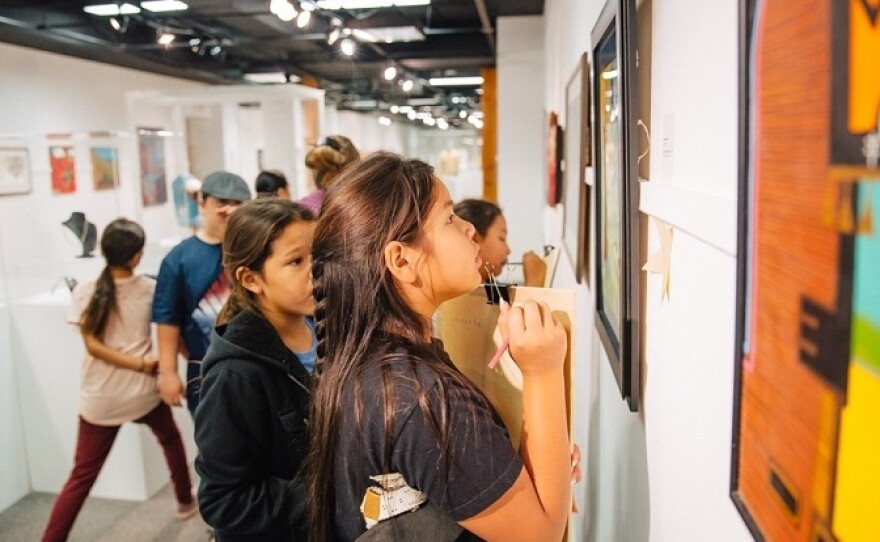 Students examine artworks on display at the Heritage Center at Red Cloud.