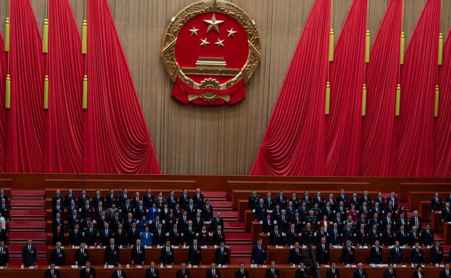 Delegates including Chinese President Xi Jinping (center) stand as the national anthem is sung during the closing session of the National People's Congress at the Great Hall of the People in Beijing, Thursday.