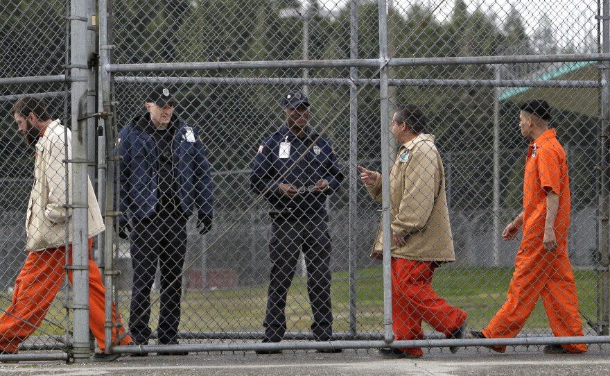 Inmates walk past correctional officers at the Washington Corrections Center in Shelton, Wash., in 2011. Gov. Jay Inslee said on Tuesday that more than 3,000 prisoners in Washington have been mistakenly released early since 2002 because of an error by the state's Department of Corrections.