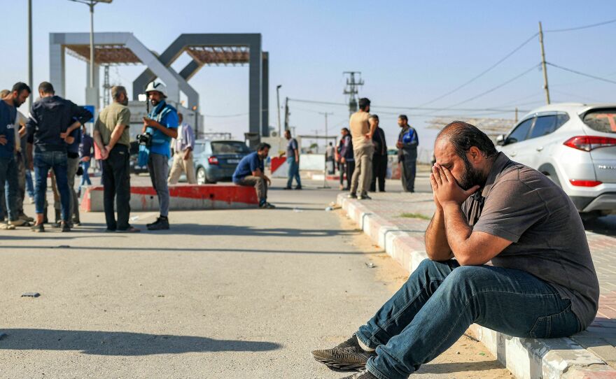 A man reacts as he sits near the gate to the Rafah border crossing with Egypt in the south of the Gaza Strip on November 3, 2023.