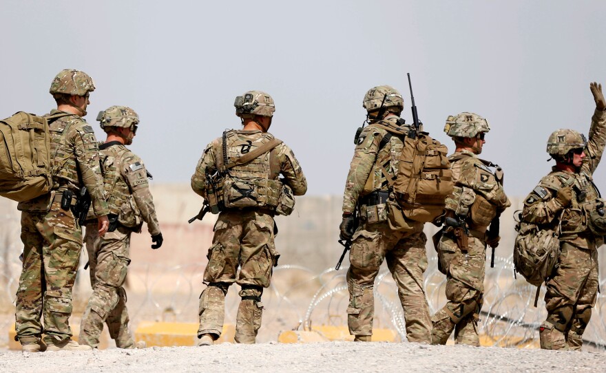 U.S. troops walk outside their base in Uruzgan province, Afghanistan, on July 7. President Trump has presented a new approach to the conflict there.