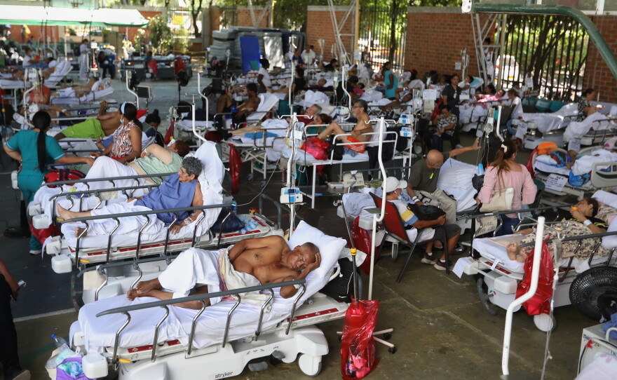 Patients from a clinic evacuated due to earthquake damage lie in beds at a temporary facility set up in a gymnasium at a nearby school in Cali, Colombia, Tuesday, Aug. 11, 2026.