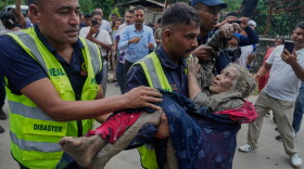 Rescuers carry a victim of flash flooding to safety along the Trishuli River in Nepal's Nuwakot district, Wednesday, Aug. 26, 2026.