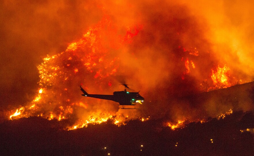 A helicopter prepares to drop water at a wildfire in Yucaipa, Calif., on Sept. 5, 2020.