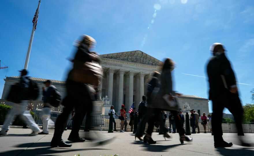 People walk by as supporters of Jan. 6 defendants gather outside of the Supreme Court on Tuesday.
