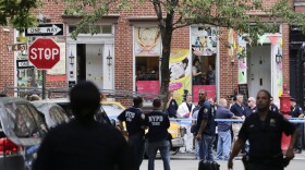 Police officers stand guard at the scene of a shooting in the Greenwich Village neighborhood in New York, July 28, 2014.