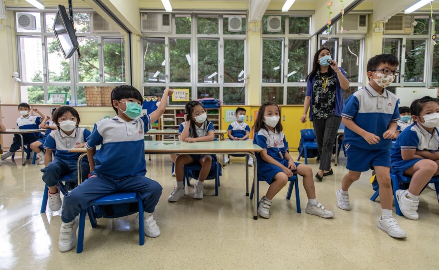 Children and staff wear masks inside a classroom.