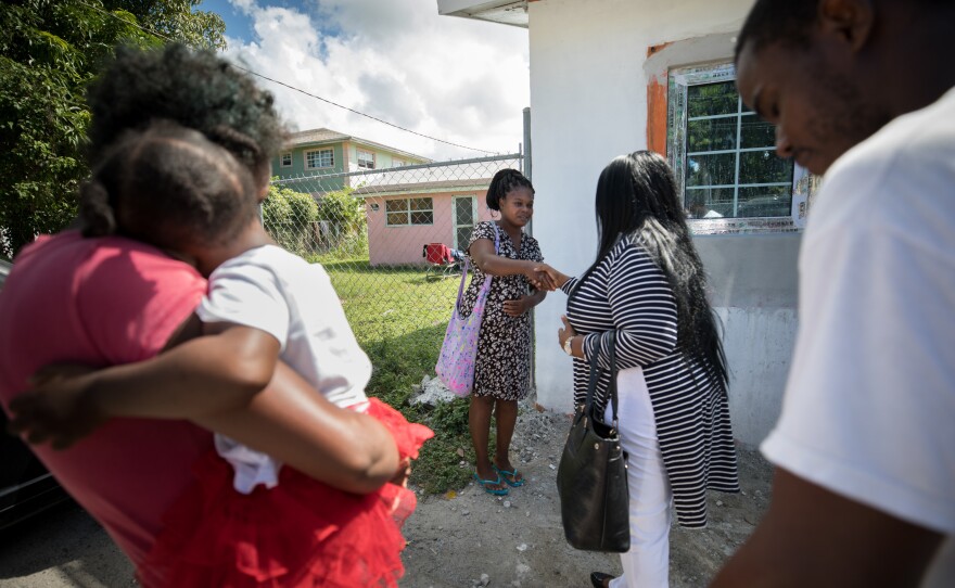 Sherrine Petit Homme LaFrance (in print dress) meets about an apartment to rent in Nassau.