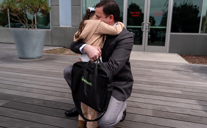 Milenko Faria hugs his daughter, Milena, after his asylum interview at the U.S. immigration facility in Tustin, Calif. on Thursday, April 16, 2026, when wife, Dr. Rubeliz Bolivar, was in custody. Bolivar, an emergency room doctor, was released last week.