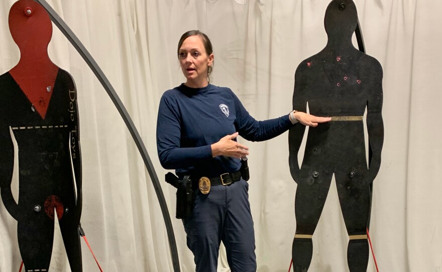 Sgt. Theresa Magyera, who oversees training and recruitment, stands near figures used to teach less lethal weapons methods.