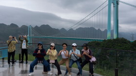 Tourists pose for photos near the Huajiang Grand Canyon Bridge, considered to be the world's highest bridge, in Anshun in southwestern China's Guizhou province on Friday, May 29, 2026.