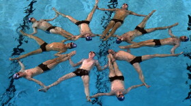 Swimmers from Sweden's all-male synchronized swimming team perform "The Flower."
