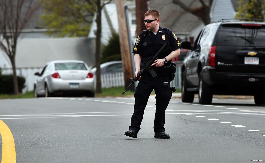 A police officer stands on the street in Watertown, Mass., during the search for bombing suspect Dzhokhar Tsarnaev on Friday.