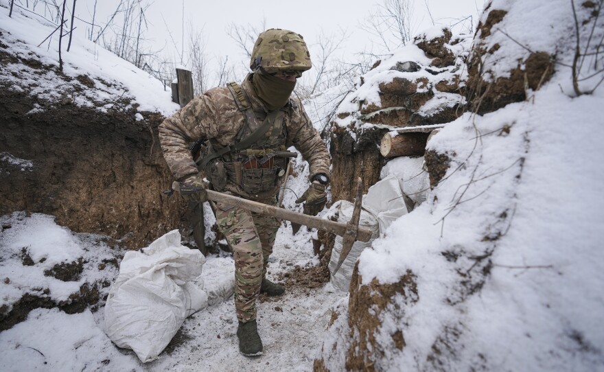 A Ukrainian serviceman works to fix a trench that was damaged by a mortar strike at a front line position in the Luhansk area of eastern Ukraine on Friday.