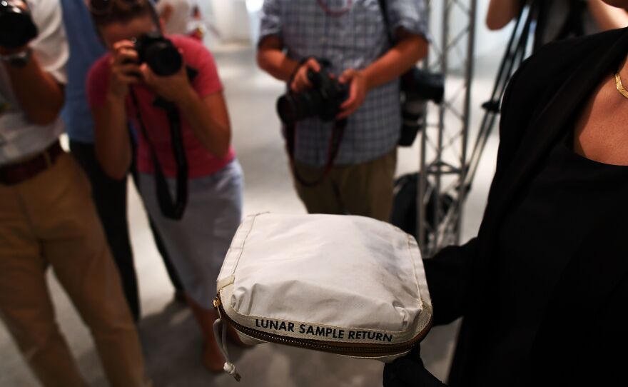 During a media preview on July 13, Cassandra Hatton of Sotheby's displays the Apollo 11 contingency lunar sample return bag. It was used by Neil Armstrong on Apollo 11 to bring back the first pieces of the moon ever collected.